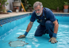 Technicien piscine inspectant liner abîmé d'une piscine extérieure
